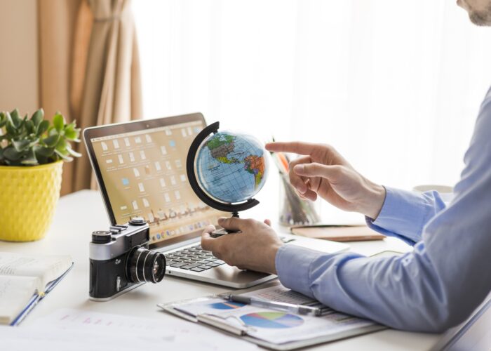 crop-man-pointing-globe-office